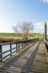  Wooden bridge with railing leading to an embankment