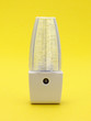 Generic LED night light on a yellow background.
