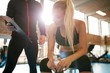 © Jacob Lund - Young woman with personal trainer looking at her fitness plan