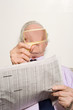 Man reading newspaper with magnifying glass