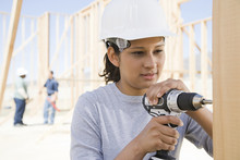 A Female Builder Drilling