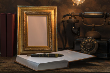 Still life of vintage telephone with picture frame and diary on