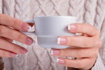 Fotomurales - Female hands hold a coffee cup.