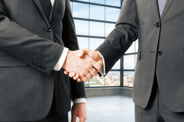 Wall Mural - Business partners shake hands in empty loft office