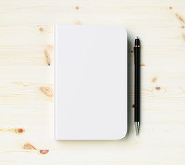 blank white diary cover with pen on wooden table, mock up