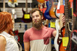 © Syda Productions - couple of musicians with guitar at music store