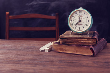 Poster - Books and clock on wooden table