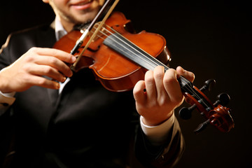 Wall Mural - Musician plays violin on black background, close up