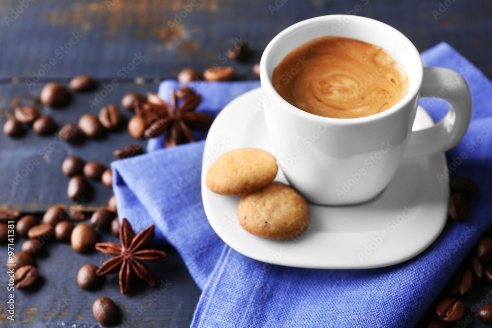 Cup of coffee with spices on wooden table background