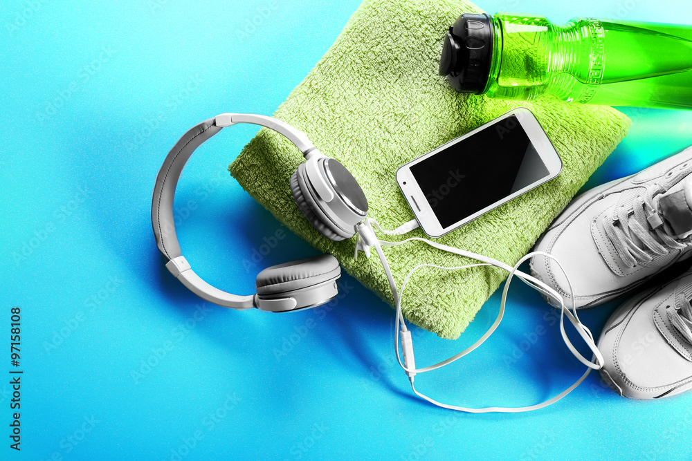 Headphones and sport equipment on blue background