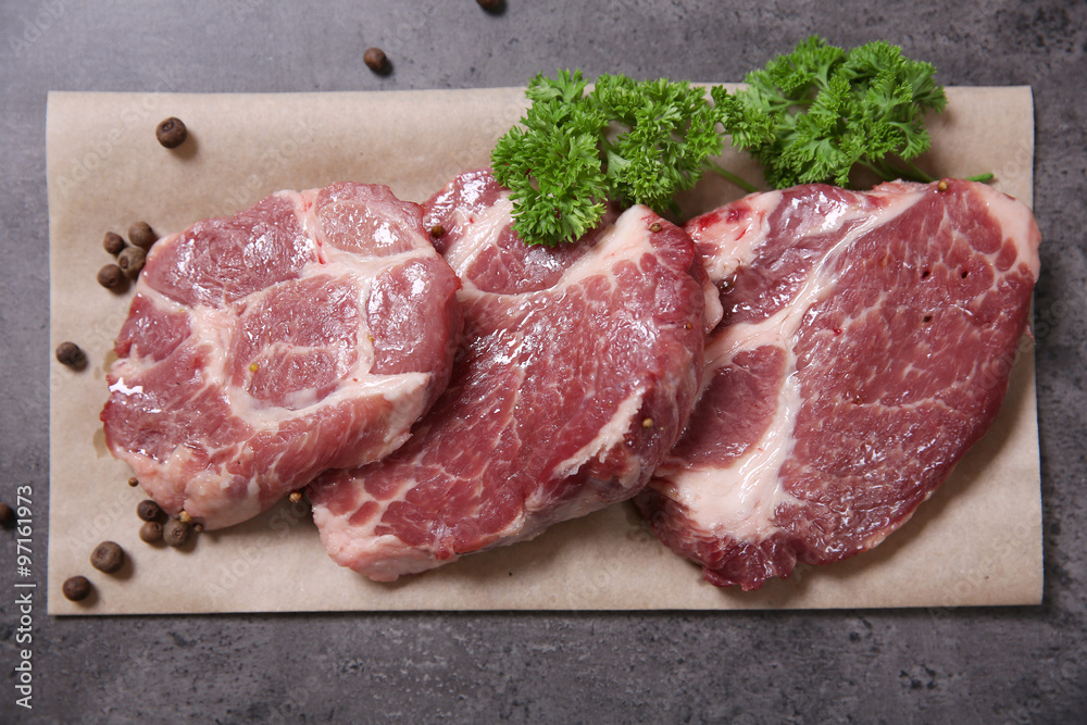 Marbled beef steak and spices on paper napkin on gray background