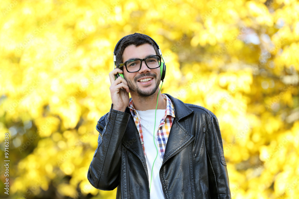 Young man in a park listening to music