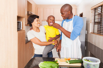 Wall Mural - african father feeding son a piece of tomato