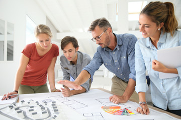 Students with teacher working on project around table