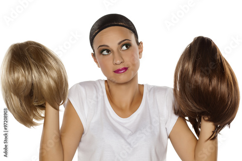 Fotomural young woman with a wig cap make a comparison between two wigs
