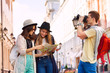 © Sergey Novikov - Two young women hold city map and guy with camera