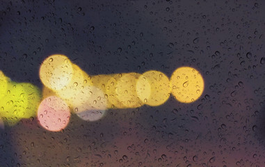 Wall Mural - Soft romantic colour bokeh light background with water or rain drop on mirror glass plate window