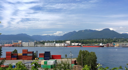 The ship under loading in the port of North Vancouver on the  mountains background
