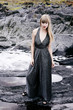 © sanneberg - Beautiful woman on rocks in gray dress, portrait