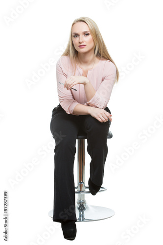 Fotografia, Obraz Elegant beautiful woman sitting on a contemporary metal bar stool