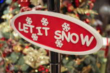 Close Up Of Christmas Decorations. Sign Let It Snow