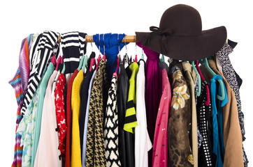 Close up on colorful clothes and hat on hangers in a store. Clothes and accessories hanging on a rack nicely arranged.