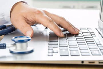 Close up of doctor's hand at computer typing