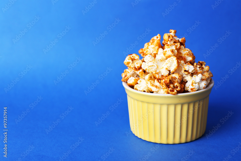 Sweet caramel popcorn on blue background