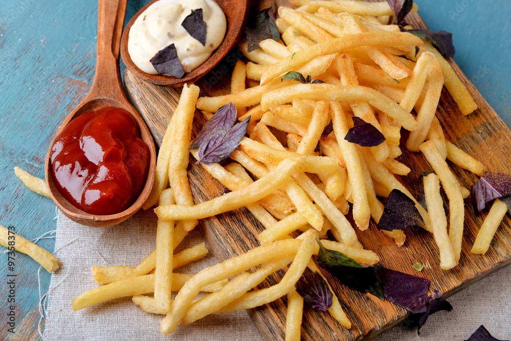 French fried potatoes with sauce on cutting board