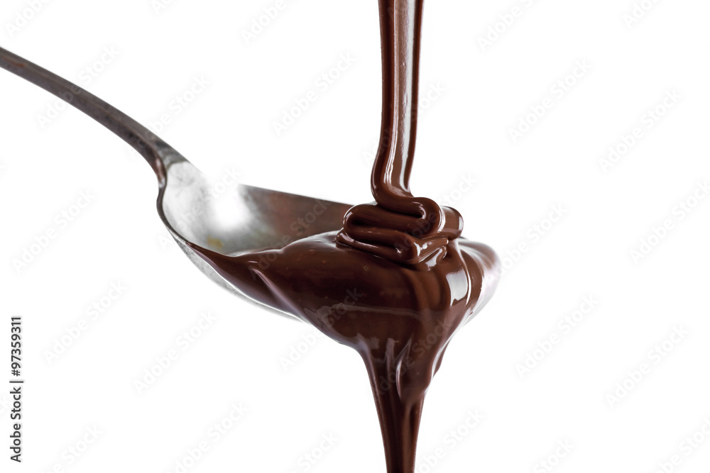 Melted milk chocolate pouring from a spoon, isolated on white
