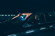 © ysbrandcosijn - Hispanic man in car at night with city lights.
