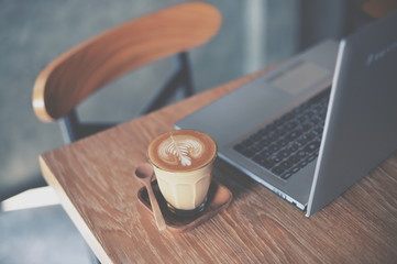 cup of coffee latte on the wood texture   in vintage color tone