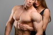 © chettythomas - Couple of athlete lovers without faces posing on grey background