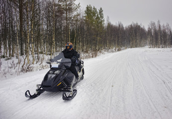 Wall Mural - Man managing a snowmobile in Ruka in Lapland