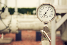 Closeup Of A High Pressure Manometer, Measuring Natural Gas Pressure. Pipes And Valves In The Background. Selective Focus