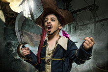 A Angry Young Boy Wearing A Pirate Costume. He Stands On The Background Of The Ship