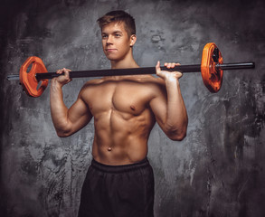 Wall Mural - Shirtles muscular young guy holds barbell.