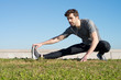 © claudiovaldes - man stretches leg in the ground