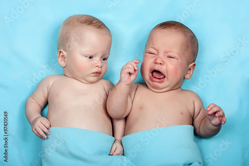 Fotografia, Obraz Twins is laughing on the blue, one looking, one crying