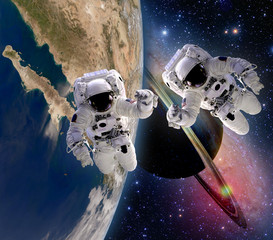 Wall Mural - two astronauts handshake spaceman sun saturn planet sci fi earth outer space galaxy. elements of thi