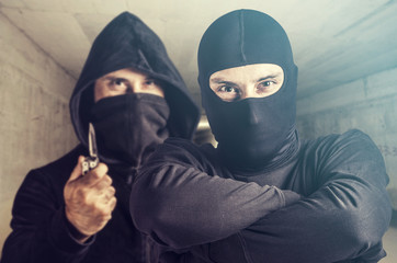 Threatening situation concept. Masked criminals