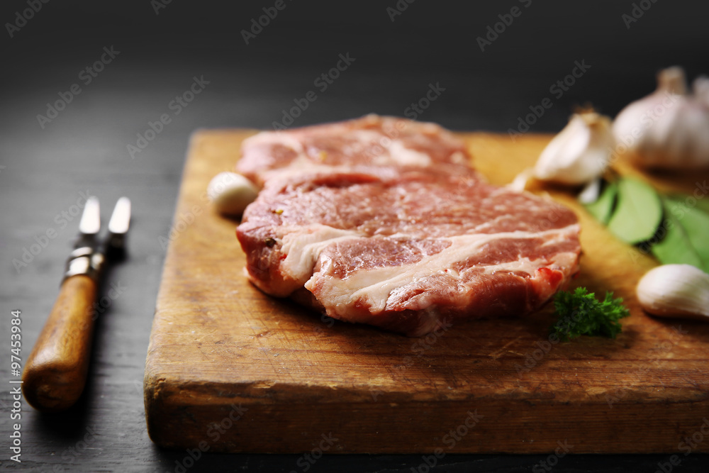 Marbled beef steak and spices on wooden background