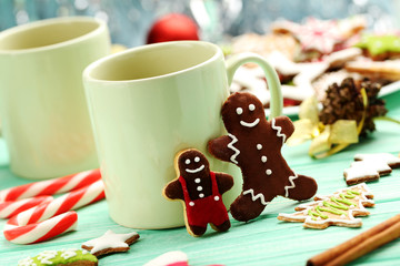 Gingerbread cookies with cup of hot coffee on a mint wooden tabl