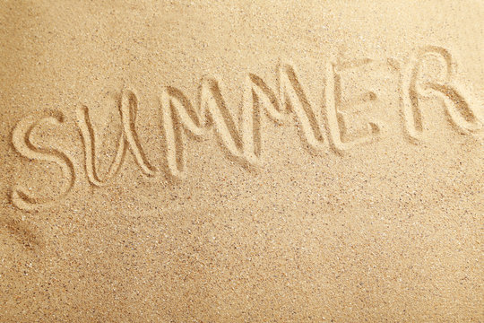 Summer handwritten in a beach sand