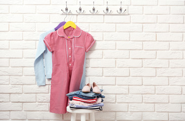 Female clothes on hangers on a brick wall background