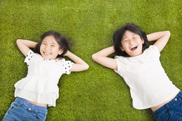 happy Little  girls resting on the grass