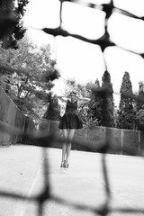 Wall Mural - beautiful slim tennis girl with dark hair wears sports clothes, posing on tennis court