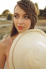 Wall Mural - beautiful young woman with long dark hair wears elegant dress and hat