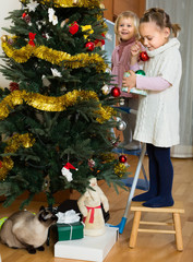 Wall Mural - Two little girls decorating Christmas tree