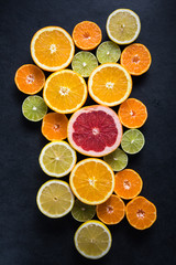 Wall Mural - Citrus half cut fruits on dark background